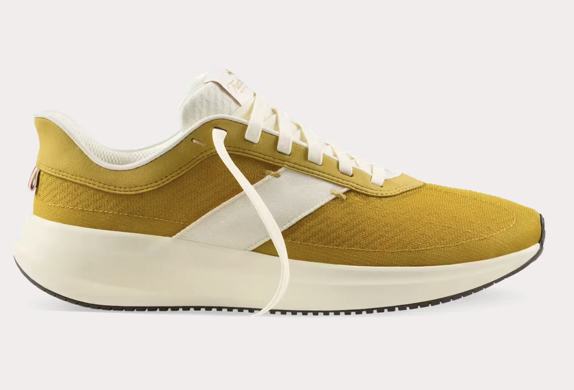 Tracksmith Eliot Runner in Ivory Gold colorway with PEBA midsoles and retro-inspired design.
